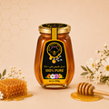 A glass jar of honey with a black and gold label reading '100% PURE' and 'Golden Honey Jar,' styled on a beige background with a honeycomb pattern, flowers, a honeycomb piece, and a wooden honey dipper.